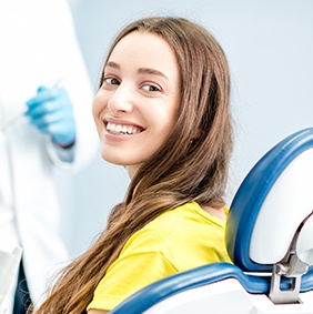 Smiling woman in dental chair after restorative dentistry