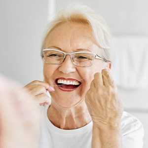 Woman smiling while flossing her teeth