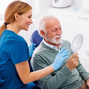 Dentist and patient looking at reflection in handheld mirror