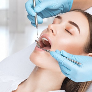 A young woman getting teeth checked by a dentist