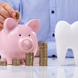 Tooth and piggy bank for cost of tooth extraction in Haverhill