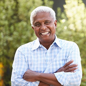 Senior man smiling with his arms folded