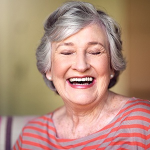 Senior woman sitting on a couch and laughing