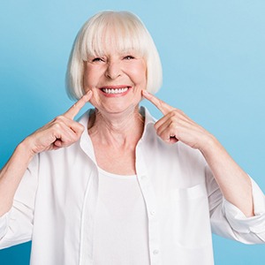Senior woman pointing to her dentures