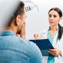 dentist speaking to a patient who is in pain