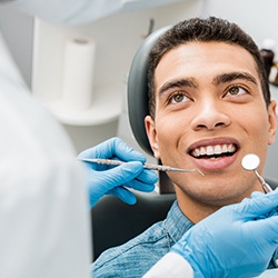 Man receiving dental checkup from emergency dentist