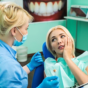 Woman in pain at emergency dentist.