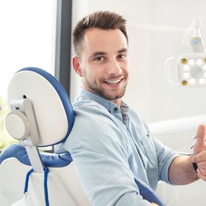 smiling man in dental chair after wisdom tooth extractions in Haverhill 