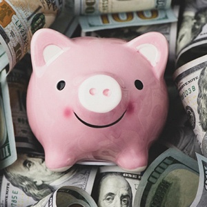 Piggy bank on money for dental implants in Haverhill