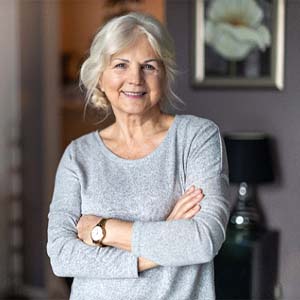 Older woman smiling after dental implant tooth replacement