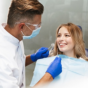 woman smiling at her dentist getting answers to frequently asked dental implant questions
