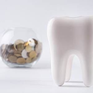 fake tooth next to a jar filled with coins