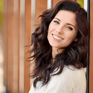 a woman smiling after undergoing a smile makeover