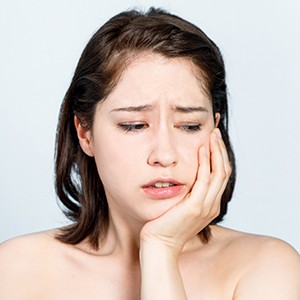 Woman with dental pain needing an emergency dentist
