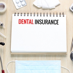“Dental insurance” written on tablet, surrounded by medical items