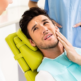 Man in pain holding jaw before emergency dentistry