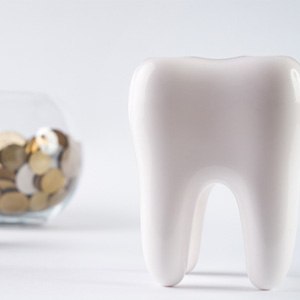 Tooth next to a pile of coins
