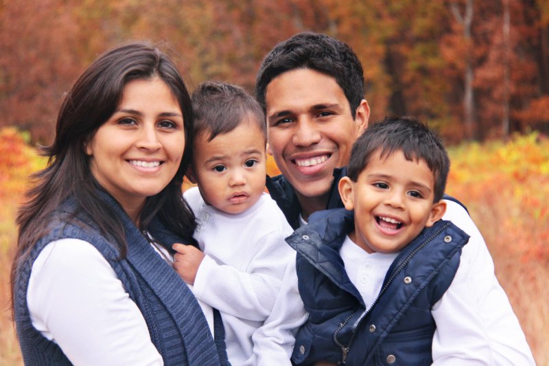 Family of four smiling hugging