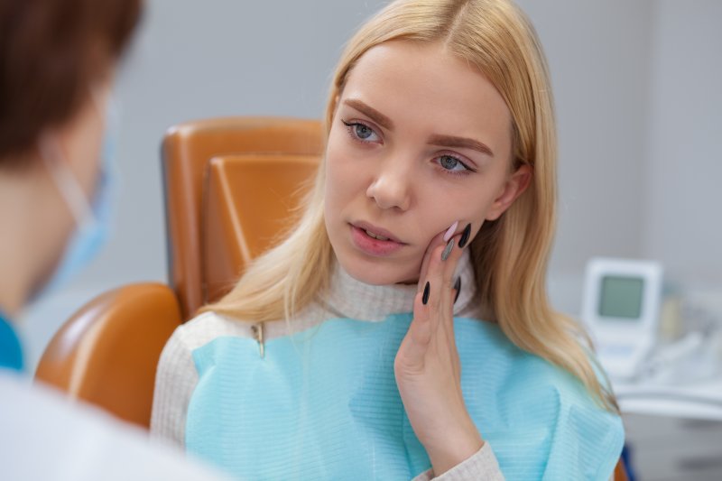 Woman talking to dentist about tooth pain