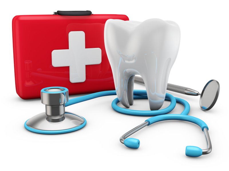 Tooth and stethoscope next to an emergency kit