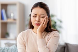 Woman holding face in pain from toothache. 